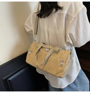 Side view of beige nylon crossbody bag with metal zippers shown on a fashion model