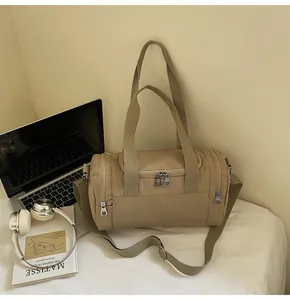 Khaki nylon cylindrical duffel bag featuring dual handles and adjustable shoulder strap
