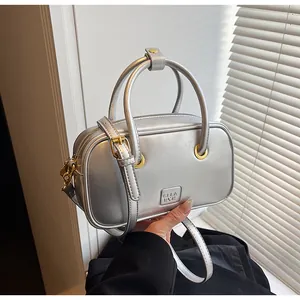 Detail of silver metallic handbag featuring gold hardware and GLEA RUK logo branding