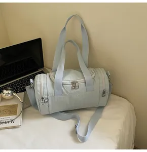 Close-up of mint green cylindrical gym bag with dual handles and adjustable strap