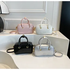 Collection of minimalist square crossbody bags in pink, white, black, and silver finishes