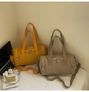 Detail view of stylish lightweight nylon barrel bag with adjustable straps in a home setting