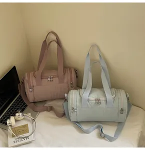 Detail of nylon bucket bags in pink and green with adjustable straps and multi-pockets