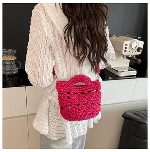 Detail der drachenfruchtpink gewebten Beuteltasche mit hohler Häkelstruktur und Gurt
