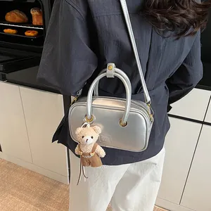 Silver metallic Boston handbag for women with adjustable strap and cute teddy bear charm