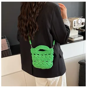 Detail einer grünen Häkeltasche mit Bienenwabenmuster und langem Schulterriemen