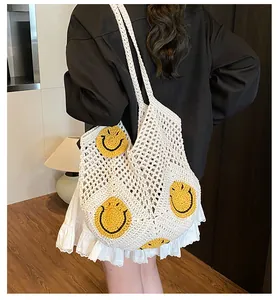 Close-up of hand-crocheted white straw tote bag featuring yellow smiley face patterns