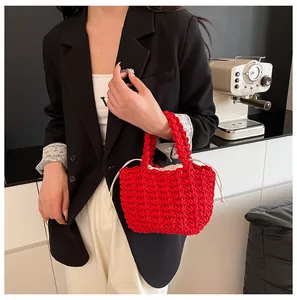 Dettaglio della borsa in maglia rossa con fodera color crema e trama a maglia a V spessa