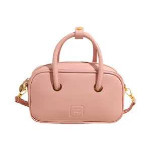 Pink leather shoulder bag with a top handle and gold zipper hardware on a white background