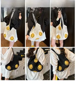 Detail view of woven mesh tote bags featuring yellow smiley faces in black and white colors