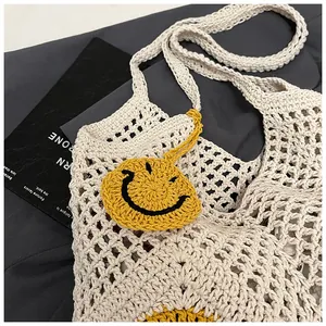 Detailed close-up of handmade crochet straw tote bag with yellow smiley face patch