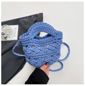 Detail der himmelblauen Webhandtasche mit Textur und geflochtenem Schulterriemen