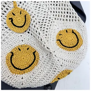 Macro shot of hand-crocheted straw tote with yellow smiley face embroidery detail