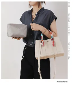 Dettaglio della borsa tote con manico in seta e pochette abbinata in pelle martellata