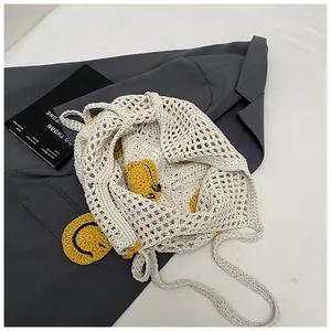 Detail of crochet tote bag with smiley patches on mesh woven texture over a blazer