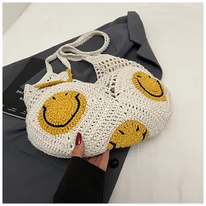 Detailed view of hand-knitted cream tote bag featuring yellow crochet smiley face patterns