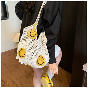 Detail view of woven straw tote bag featuring three yellow smiley face crochet patches