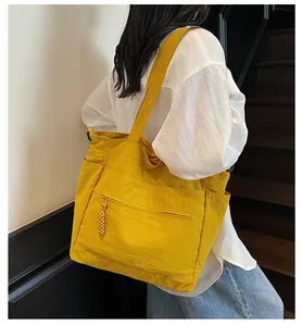 Dettaglio della borsa tote gialla in nylon con tessuto strutturato e zip in tessuto
