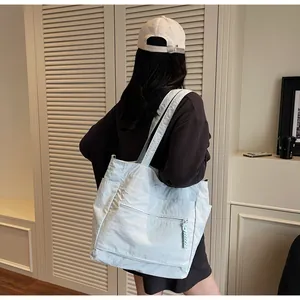 Vista posteriore di una borsa tote in nylon celeste con capienza ampia e spalline