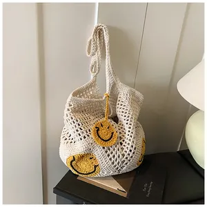 Detail of hand-woven crochet mesh tote with yellow smiley face patterns for beach vacation
