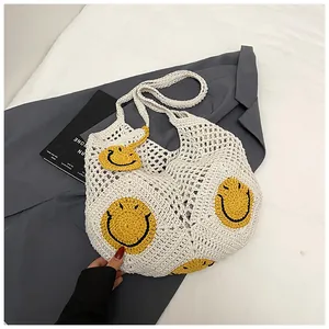 Close-up of handmade white crochet tote bag with embroidered yellow smiley faces
