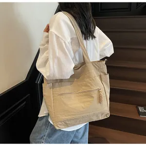 Dettaglio della borsa tote in nylon con tasca frontale a zip e tasche laterali