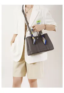 Dettaglio borsa tote grigia in pelle martellata con foulard di seta e fibbie in metallo