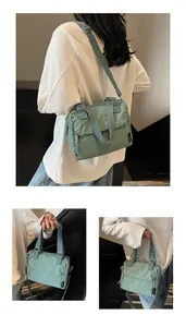 Vue détaillée du sac en toile vert clair montrant la fermeture éclair et l'étiquette