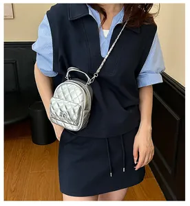 Gros plan d'un mini sac à dos argenté matelassé avec des chaînes en métal et texture cuir chic