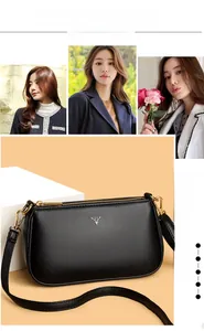 Detail of black pebbled leather crossbody bag with silver deer logo and gold zippers