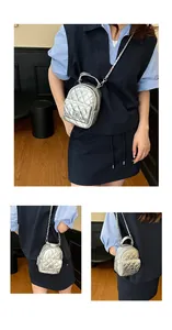Vue détaillée du mini sac à dos argenté matelassé avec chaîne et fermoir pivotant