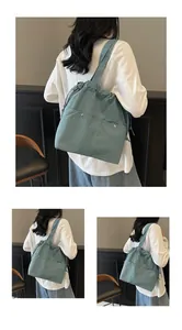 Close-up of waterproof nylon tote bag with drawstring closure and silver metal buckle pockets
