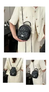 Détail macro du mini sac à dos noir matelassé avec fermoir rotatif argenté et chaîne