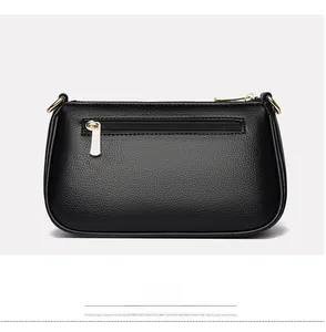 Detail view of black pebble leather shoulder bag back showing zipper pocket and gold hardware