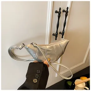 Detail der silbernen Metallic-Sichel-Tasche mit Steppmuster und Seitenprofil