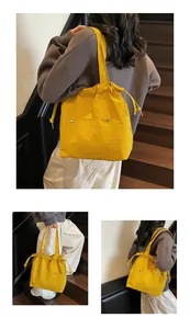 Macro detail of vibrant yellow waterproof nylon tote bag with drawstring closure and silver rivets