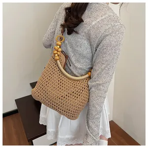 Detail of hand-woven shoulder bag featuring unique wooden bead strap and net mesh pattern