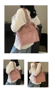 Detail of dusty pink nylon tote bag featuring drawstring closure and silver buckle pockets