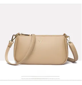 Close-up of beige crossbody bag showing lychee leather texture and golden deer logo