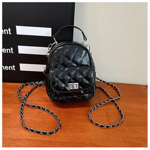 Détail du mini sac à dos noir matelassé avec bandoulière chaîne et fermoir argenté