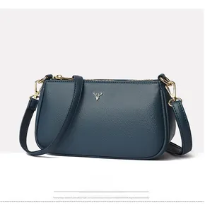 Close-up of navy blue pebbled leather handbag featuring a golden stag metal logo