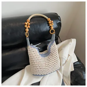 Detail of handmade woven shoulder bag with wooden beads and secure zipper closure