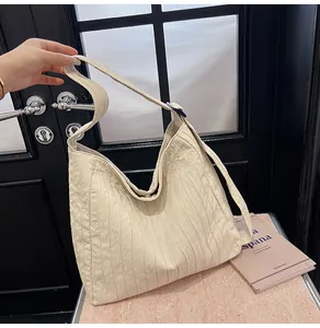 Vue détaillée du sac cabas beige avec tissu plissé et bandoulière large intégrée