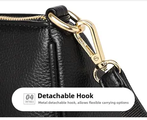 Detail of detachable gold-tone metal hook on black pebbled leather crossbody bag