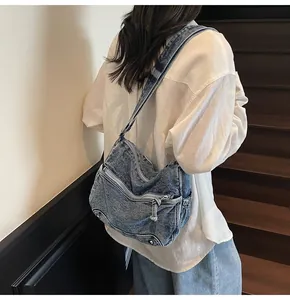 Dettagli della borsa a tracolla in denim blu con zip multiple e tracolla regolabile