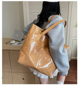 Detailansicht der großen transparenten PVC-Einkaufstasche mit braunem Innenbeutel und Aufdruck