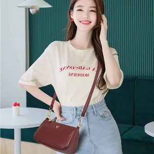 Burgundy vintage leather crossbody bag with gold deer logo shown on elegant model