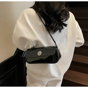 Detail der glänzenden schwarzen Lackleder-Baguette-Tasche mit silberner Drehschnalle