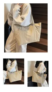 Detail of minimalist beige nylon tote bag showing multiple functional exterior side pockets