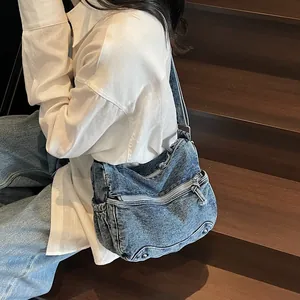 Borsa a tracolla in denim blu lavato retrò con tasche multiple indossata da modella